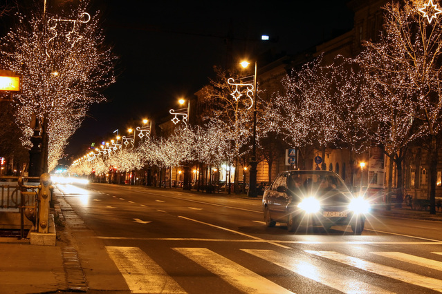 svítící auto jede noční ulicí